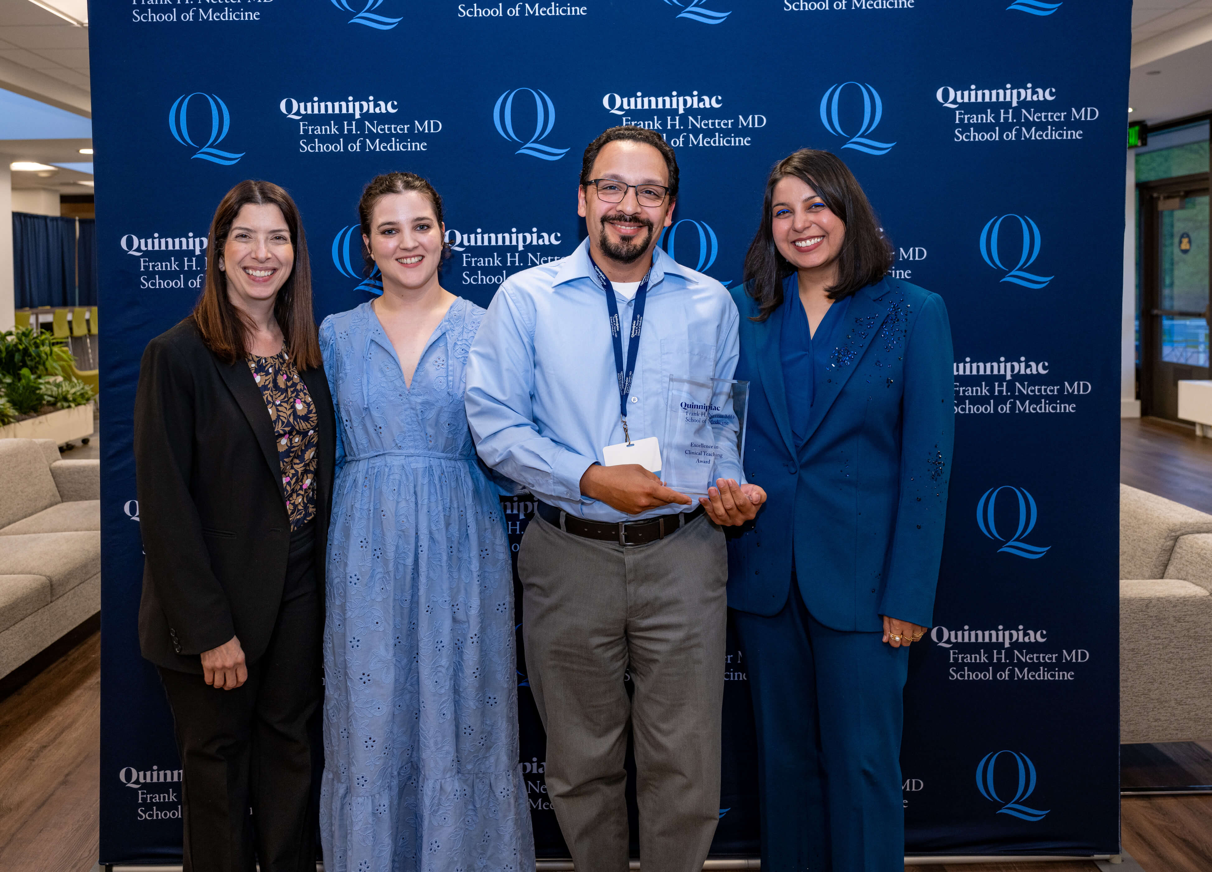William Santiago poses with award and three other people